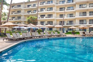 A hotel pool area with lounge chairs and umbrellas, surrounded by a multi-story building with balconies. - Awesome oceanfront resort with amazing Arch views in fabulous Cabo San Lucas (Cabo San Lucas)