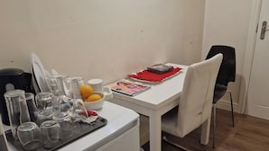 A compact kitchen with a refrigerator, a dining table with chairs, and various kitchen utensils and appliances. - A Room Double bed 2 People With Hob and Fridge (London)