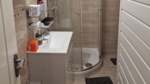 A modern bathroom with a glass shower enclosure, a white sink, and a mirror. - A Room Double bed 2 People With Hob and Fridge (London)