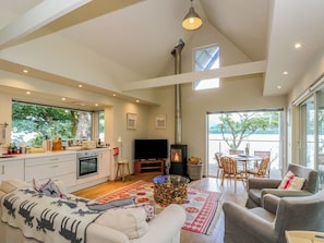 A spacious living area with a fireplace, a dining area, and a kitchen.