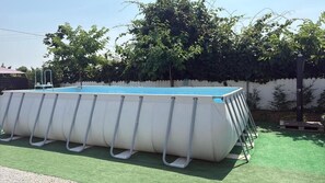 An above-ground swimming pool with a ladder, surrounded by a white fence and greenery. - Il Giardino dei Sensi (Tarantasca)