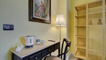 Une chambre d’hôtel équipée d’un bureau, d’une chaise, d’une lampe, d’un tableau et d’une armoire en bois.