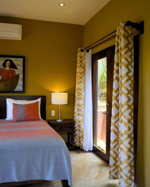 Une chambre d’hôtel avec un lit, une table de chevet, une lampe, un tableau au mur et une fenêtre avec des rideaux.