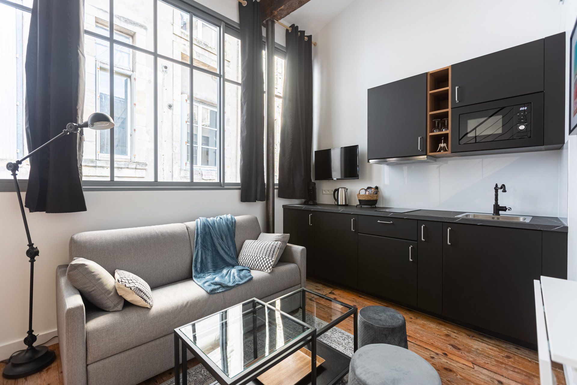 A modern kitchen with a flat-screen TV, a coffee maker, and a microwave.