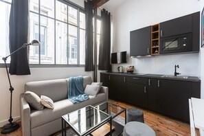 A modern kitchen with a flat-screen TV, a coffee maker, and a microwave. - Elegant AC duplex in the very heart of Bordeaux (Bordeaux)