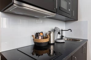 Eine moderne Küche mit Edelstahlgeräten, einer Kaffeemaschine und einer Kaffeebohnen-Korb.