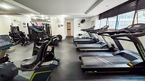 Et fitnessrum med løbebånd, crosstrainere og styrkemaskiner.