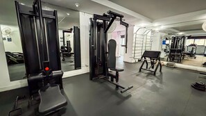 A gym with exercise equipment, mirrors, and a weight bench. - SHB Lazer Completo 2min da Praia (Guarujá)