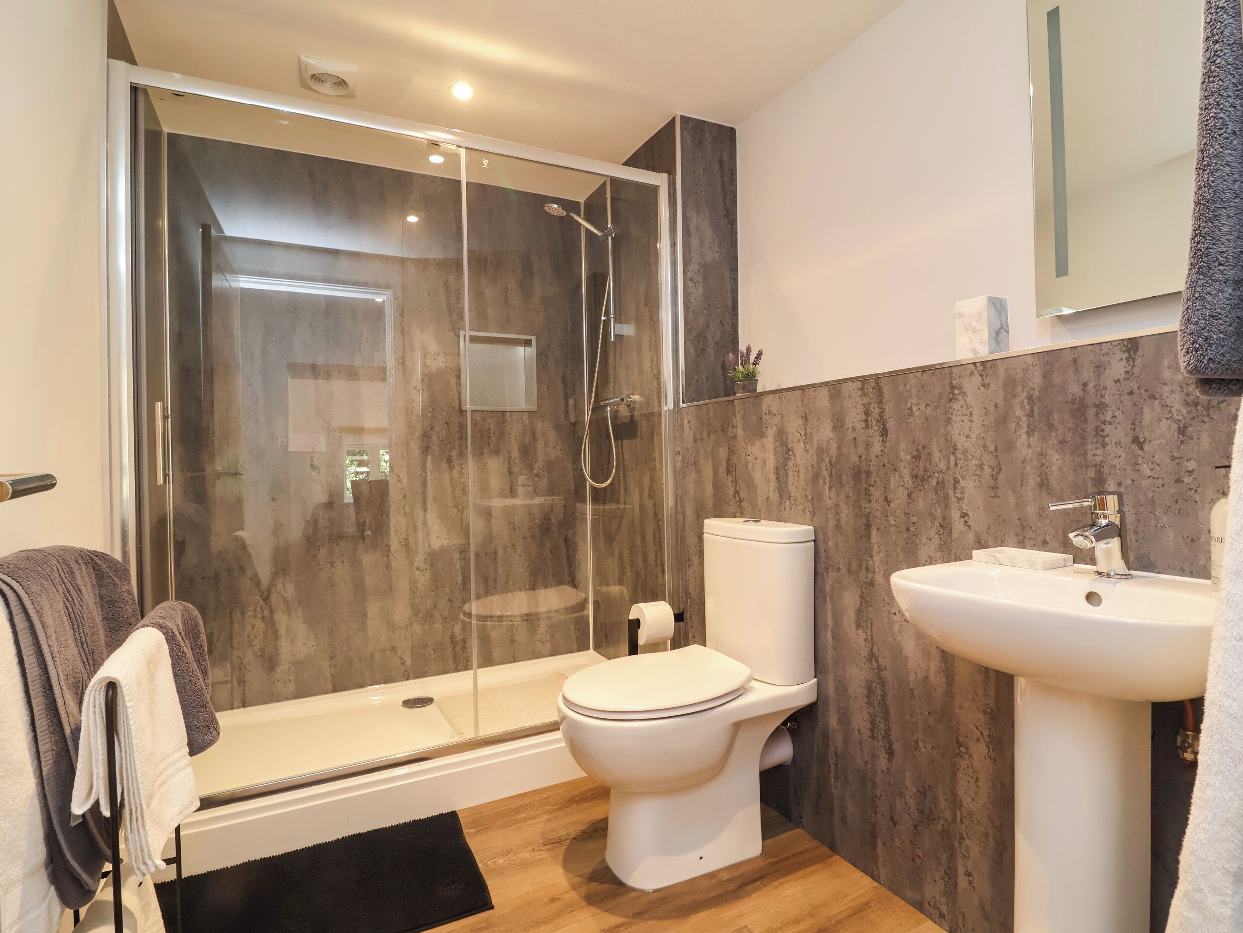 Ein modernes Badezimmer mit einer Duschkabine, einer Toilette und einem Waschbecken.