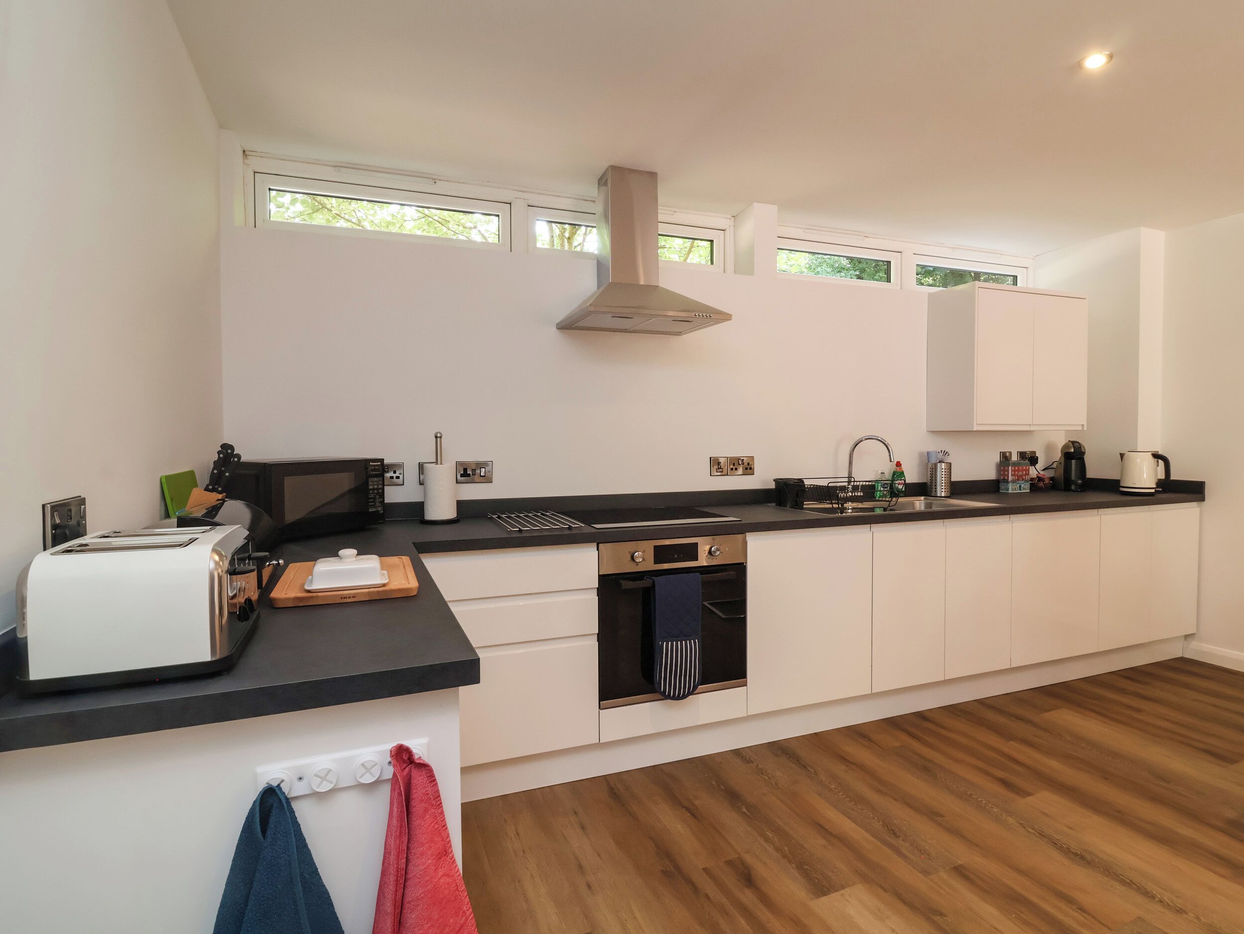 A modern kitchen with a built-in oven, a microwave, and a sink.