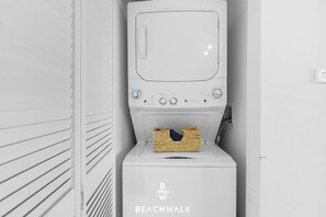 A compact, white, wall-mounted washer and dryer unit with a control panel and a basket for laundry. - Intracoastal View Apt - Resort Amenities & Pool (Hallandale Beach)