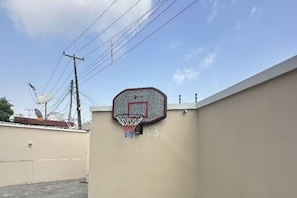 A basketball hoop attached to a wall, with power lines and a satellite dish in the background. - Deluxe Studio Suite, Kitchenette, Garden View (Lagos)