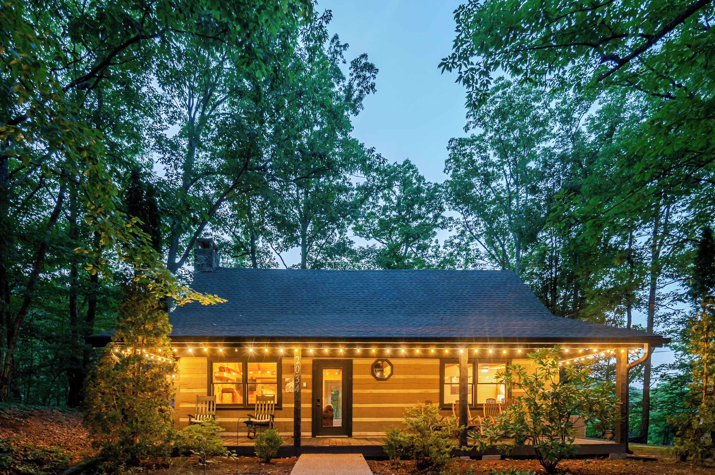 A cabin with a porch, a door, and a small window.