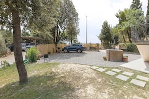 A gravel driveway leading to a parked car, surrounded by trees and a fence. - Apartment 'Mini Cielo' with Shared Garden, Wi-Fi and Air Conditioning (Volterra)