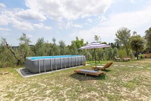 A backyard with a rectangular swimming pool, lounge chairs, and a patio table. - Apartment 'Cielo' with Shared Garden, Wi-Fi and Air Conditioning (Volterra)