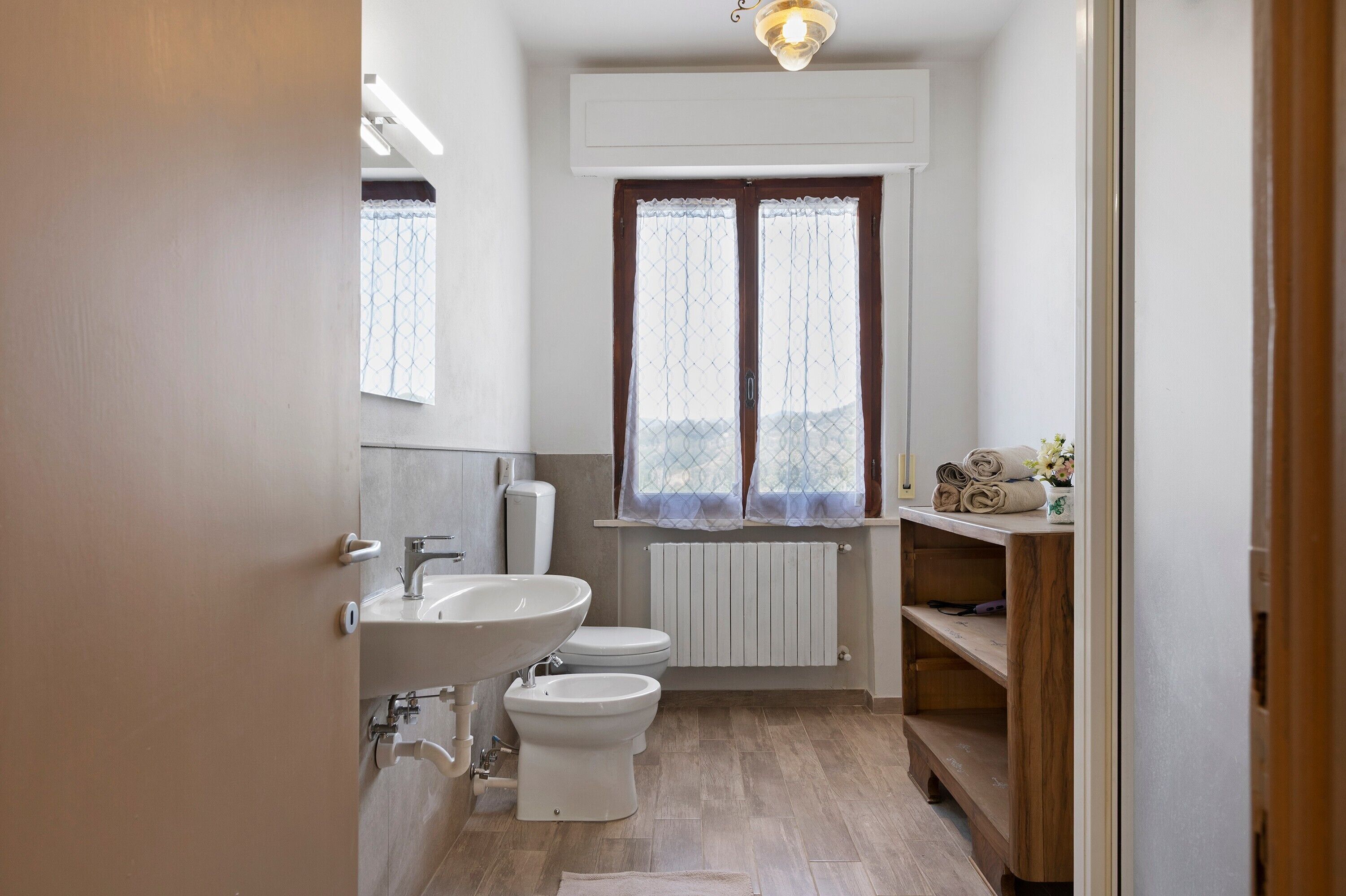 Un bagno con il water, un lavandino e una finestra.