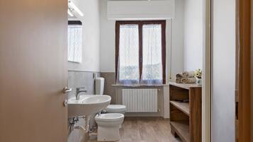 Un bagno con il water, un lavandino e una finestra.
