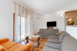 Ein Wohnzimmer mit einer Couch, einem Fernseher und einem Couchtisch.