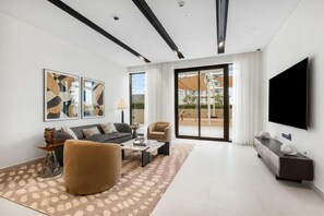 A modern living room with a sofa, armchair, coffee table, and artwork on the wall. - StayShort | Stunning Beachfront 2-Bedroom Apartment Sleeps 6 with Infinity Pool, Skyline Views & Private Beach Access (Dubai)