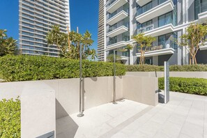 A modern outdoor area with a concrete pathway, metal bollards, and greenery. - StayShort | Stunning Beachfront 2-Bedroom Apartment Sleeps 6 with Infinity Pool, Skyline Views & Private Beach Access (Dubai)