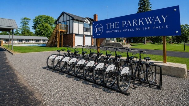Schild für das The Parkway Boutique Hotel an den Wasserfällen mit einer Fahrradverleihstation davor.