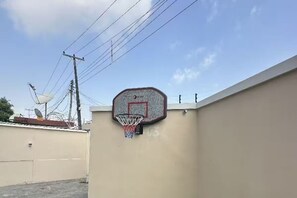 A basketball hoop attached to a wall, with power lines and a satellite dish in the background. - Luxury Apartment, 2 Bedrooms, Kitchenette, Courtyard View (Lagos)