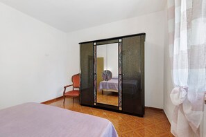 A room with a bed, a chair, and a wardrobe with a mirror. - Apartment 'Terra' with Shared Pool, Garden, and Wi-Fi (Volterra)