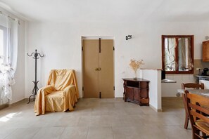 A room with a door, a chair, a cabinet, a table, and a mirror. - Apartment 'Terra' with Shared Pool, Garden, and Wi-Fi (Volterra)