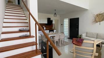 A modern interior with a wooden staircase, a dining area, and a living space.