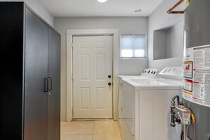 A laundry room with a door, washing machines, and a water heater. - Sam Hughes / Carport / Updated / 4BR 3BA / Fenced (Tucson)