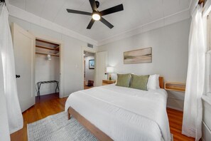 A bedroom with a bed, a ceiling fan, a nightstand, a lamp, and a painting on the wall. - Sam Hughes / Carport / Updated / 4BR 3BA / Fenced (Tucson)
