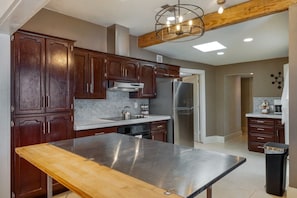 A kitchen with dark wooden cabinets, stainless steel appliances, and a marble countertop. - Sam Hughes / Carport / Updated / 3BR 3BA / Fenced (Tucson)