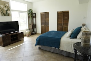 A bedroom with a bed, a television, a plant, and a window. - Expansive ranch house w/ guest suite for groups (Cochise County)