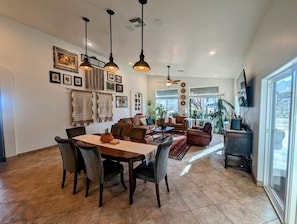 A spacious living area with a dining table, sofas, and a ceiling fan. - Expansive ranch house w/ guest suite for groups (Cochise County)