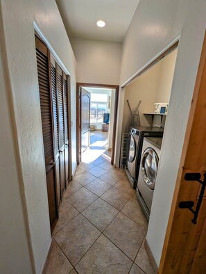 A hallway with a washing machine, a door with a handle, and a view to an outdoor area. - Spacious 2BR Getaway w/Hot Tub (Cochise County)