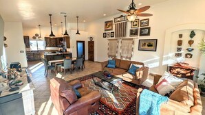 A spacious living area with a sofa, coffee table, and a dining area with chairs and a table. - Spacious 2BR Getaway w/Hot Tub (Cochise County)