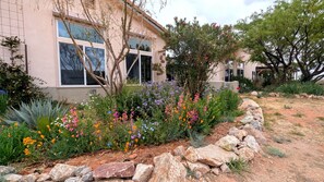 A house with a garden featuring various plants and flowers. - Spacious 2BR Getaway w/Hot Tub (Cochise County)