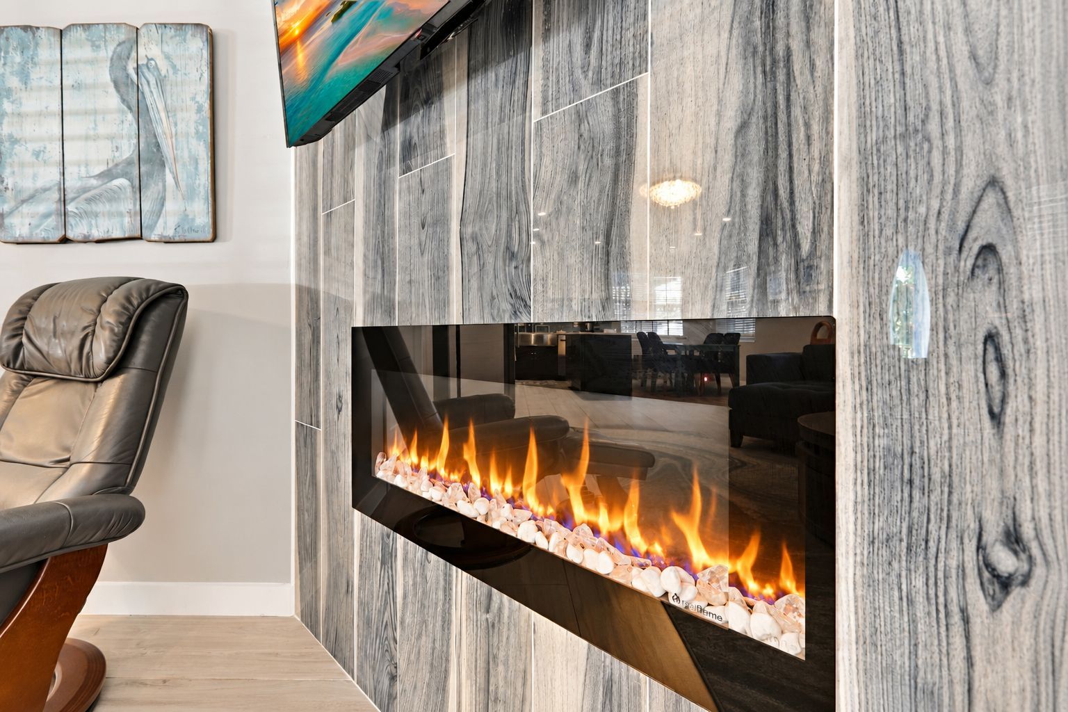 A contemporary electric fireplace embedded in a vertical tile accent wall.