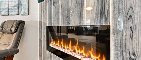 A contemporary electric fireplace embedded in a vertical tile accent wall.