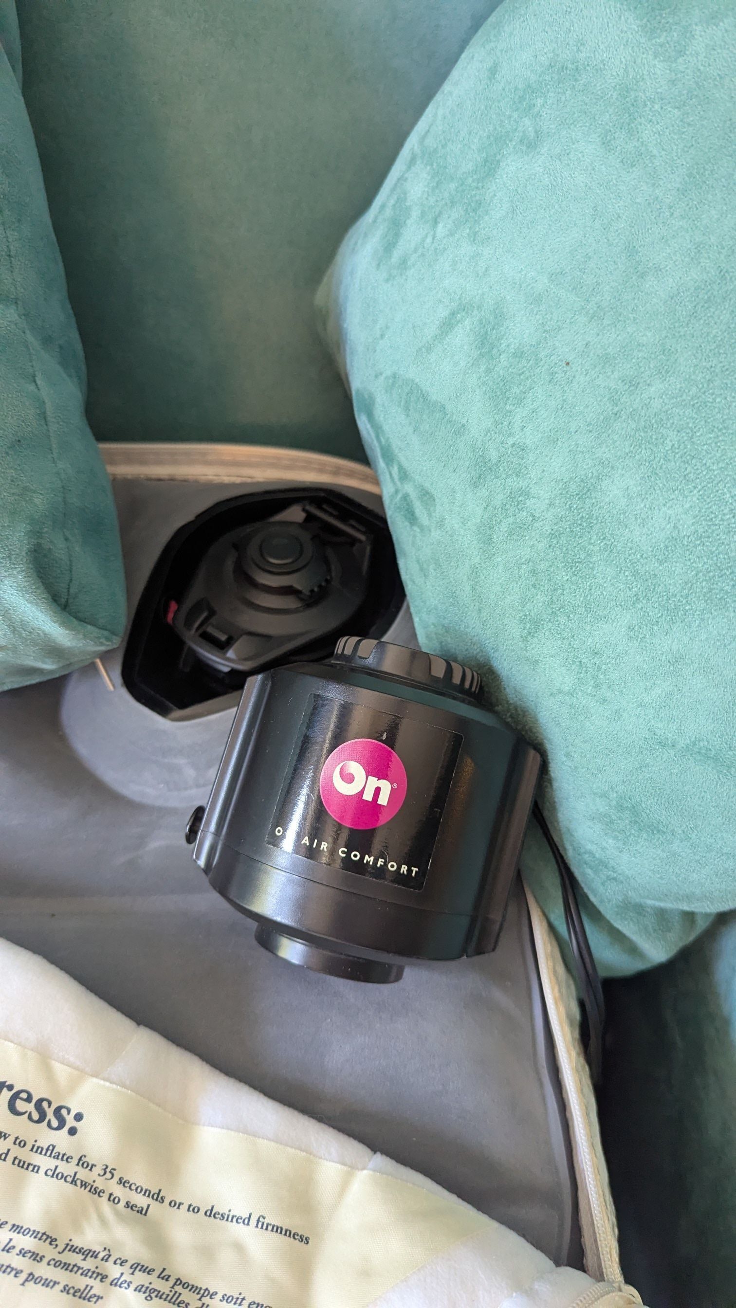 Un purificatore d'aria nero con un logo rosa etichettato 'On Air Comfort' su una superficie grigia.