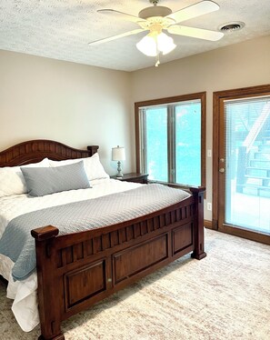 A bedroom with a wooden bed, a nightstand, a lamp, and a ceiling fan. - Ultimate Norris: Newly listed gem!  Private 
dock and year-round open water (LaFollette)