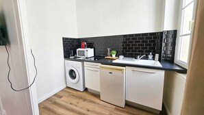 Cocina compacta con lavadora, microondas y lavaplatos.