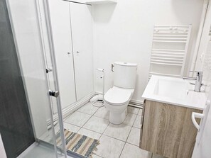 A bathroom with a toilet, sink, and shower area. - "Les Arches 2" City Center Studio (Saintes)