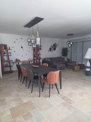 A modern dining area with a rectangular table, multiple chairs, and hanging pendant lights. - Stunning Villa with All the Comforts (1–9 People) (Tavel)