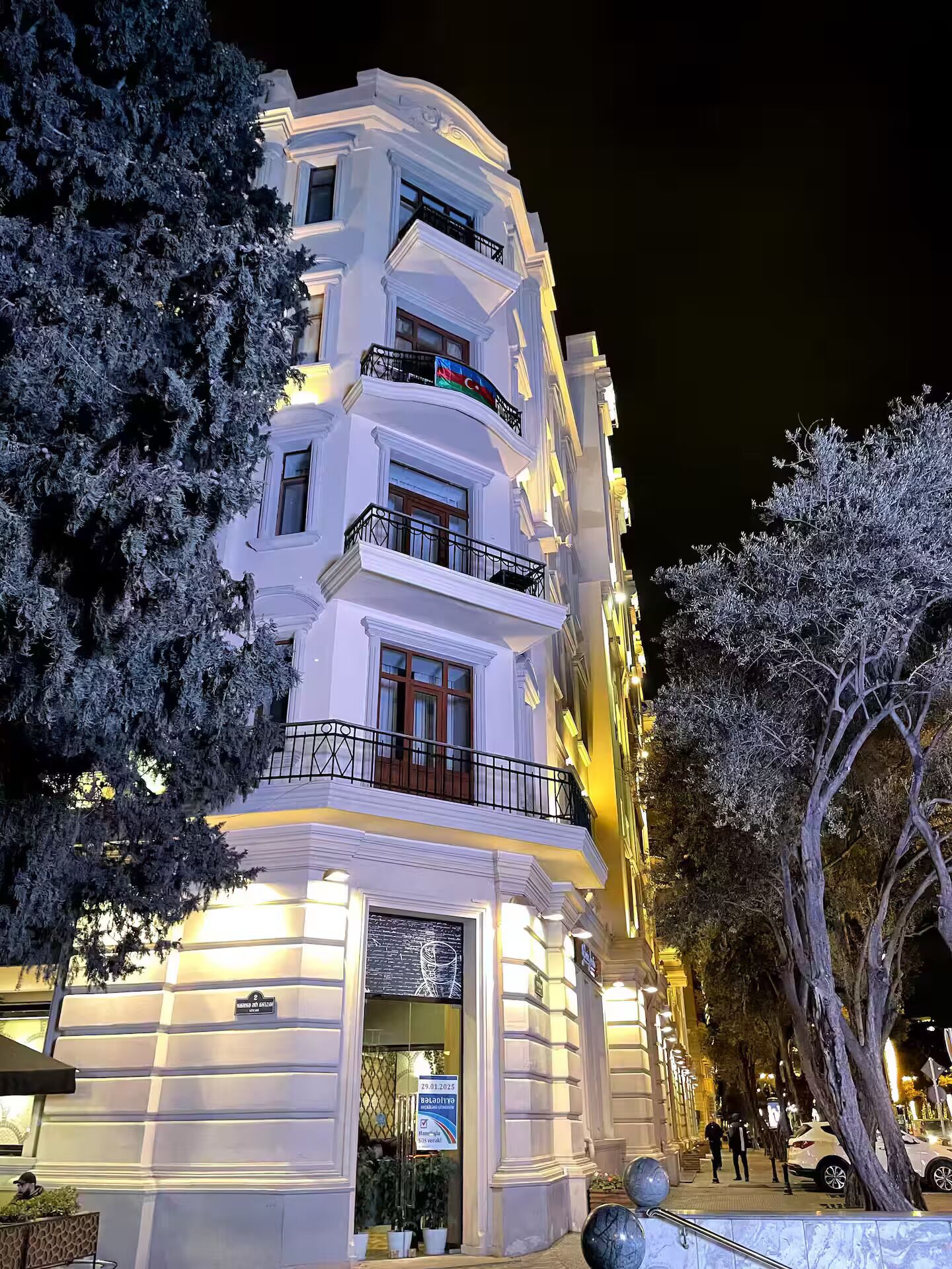 A multi-story building with balconies, a storefront, and a sign indicating a business.
