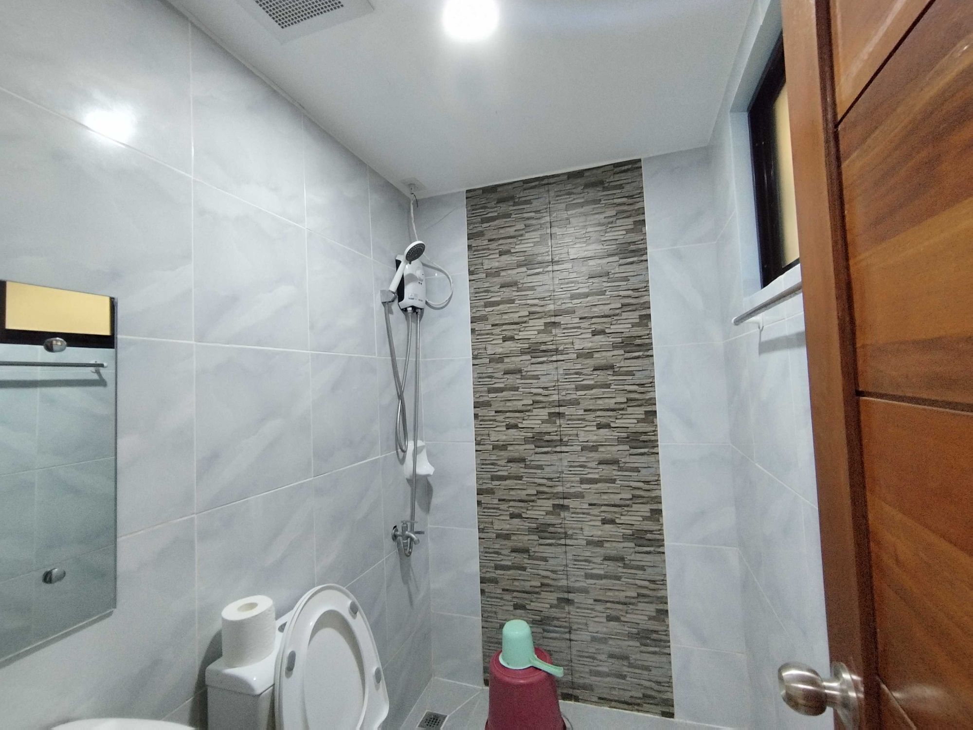 A bathroom with a toilet, bidet, and shower.