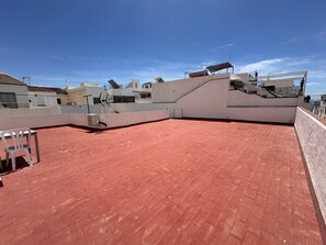 A rooftop terrace with red tiles, a white wall, and a satellite dish. - R1399, Casa Nina Pariles, Maro (Maro)