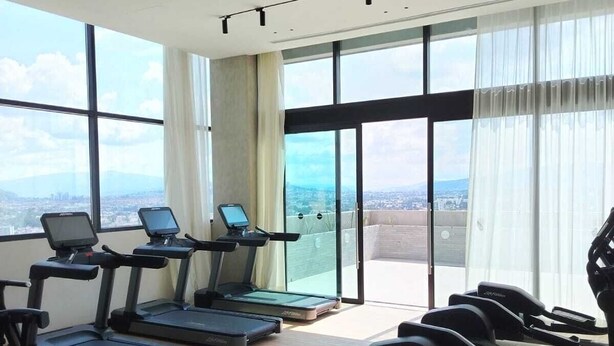 A gym with treadmills, stationary bikes, and a rowing machine. - Margot Premier Apartment (Guadalajara)