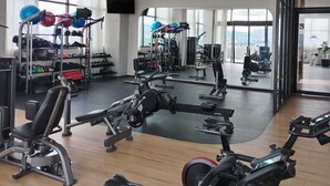 A gym with cardio machines, weightlifting equipment, and a large mirror reflecting the space. - Margot Premier Apartment (Guadalajara)