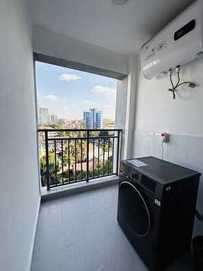 A small balcony with a view of buildings and a washing machine. - Cozy Modern Mini 2BR, Close to Yaya Centre & Top Cafes.
Gym,kids play pen, (Nairobi)
